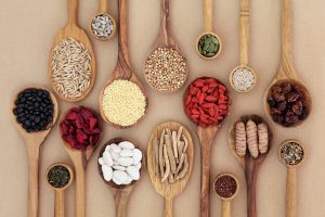 Dried super health food selection in wooden spoons over natural